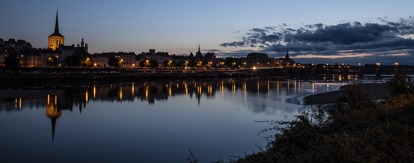 Saumur, France, Picture of the Loire river and the french market town by night